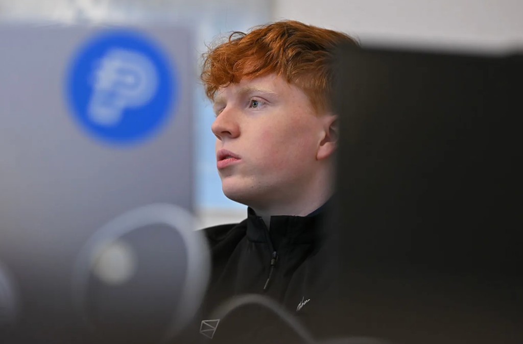Oliver Wilson seated near computer monitors